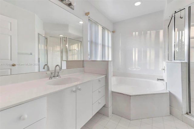 bathroom featuring tile patterned flooring, vanity, and separate shower and tub