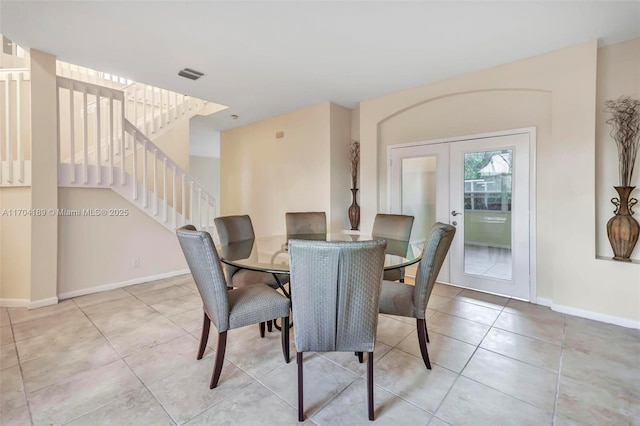 tiled dining room featuring french doors