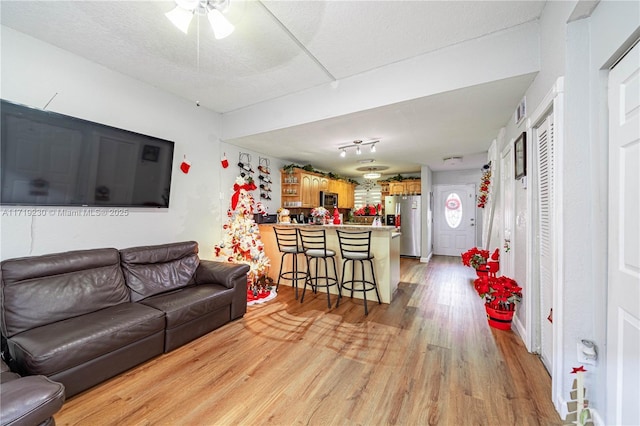 living room featuring a textured ceiling and light wood-type flooring