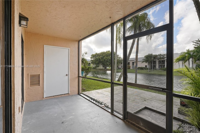 unfurnished sunroom featuring a water view and a wealth of natural light