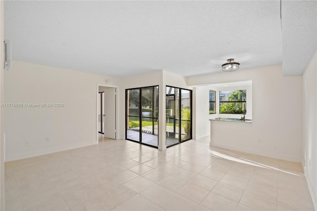 tiled spare room featuring a textured ceiling