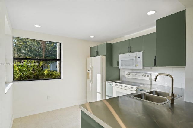 kitchen with decorative backsplash, white appliances, green cabinets, and sink