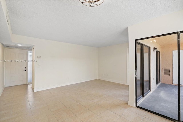 empty room with light tile patterned floors and a textured ceiling