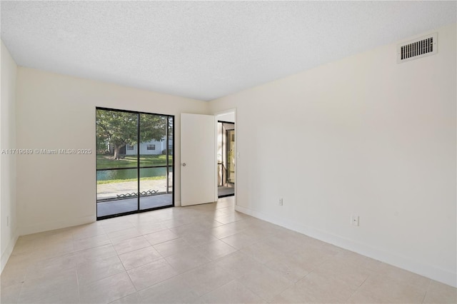 unfurnished room with light tile patterned floors and a textured ceiling