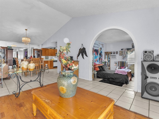 dining area with a textured ceiling, washer / clothes dryer, light tile patterned floors, and lofted ceiling