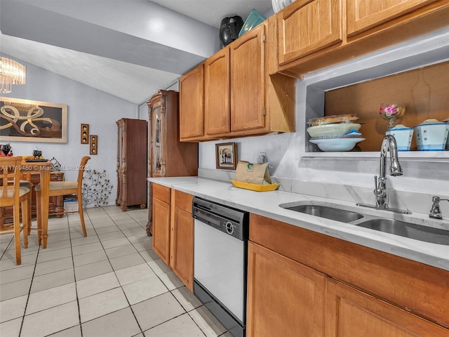 kitchen featuring dishwasher, light tile patterned floors, lofted ceiling, and sink