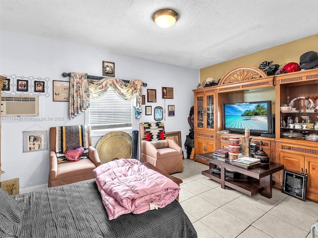 living area featuring a wall mounted air conditioner, light tile patterned floors, and a textured ceiling