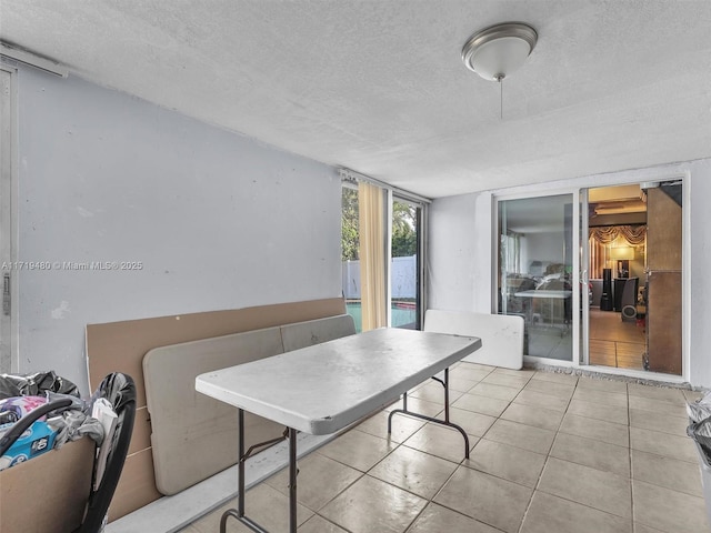 dining space featuring light tile patterned floors and a textured ceiling