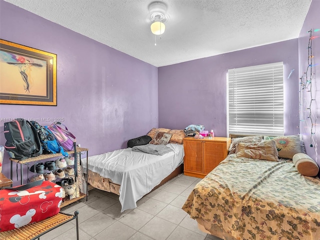 tiled bedroom featuring ceiling fan and a textured ceiling