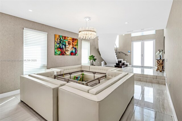 living room featuring french doors and a notable chandelier