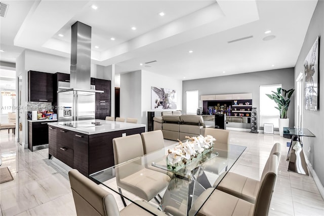 dining space with a raised ceiling