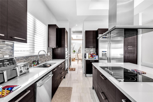 kitchen with tasteful backsplash, dark brown cabinetry, sink, and appliances with stainless steel finishes