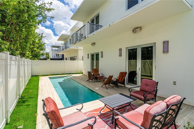 view of pool with french doors and an outdoor hangout area