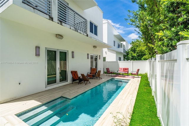 back of house featuring a pool side deck and an outdoor hangout area