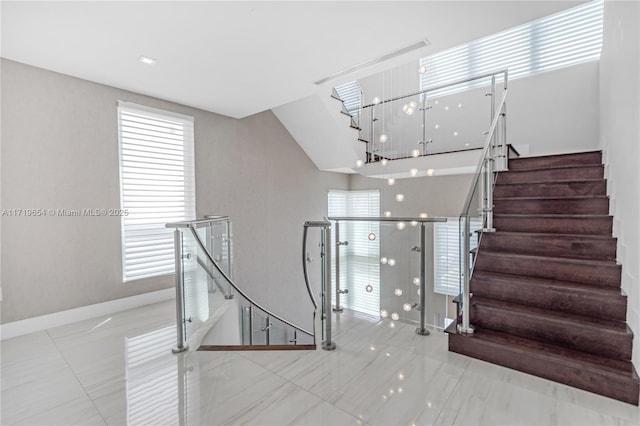 staircase with lofted ceiling and a wealth of natural light