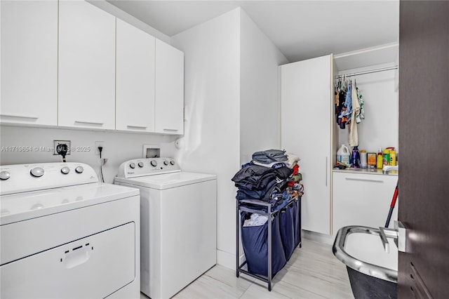 washroom featuring cabinets and washer and clothes dryer