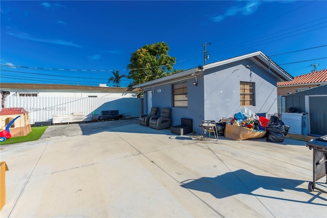 rear view of house with a shed and a patio