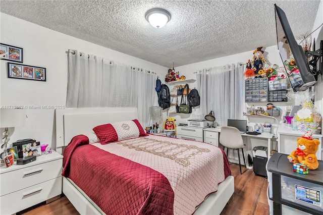 bedroom with a textured ceiling and dark wood-type flooring