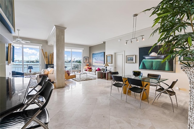 dining area featuring a water view, ceiling fan, and ornamental molding