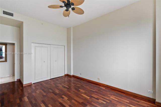 unfurnished bedroom with ceiling fan, a closet, and dark wood-type flooring