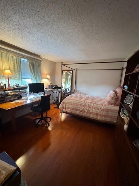 bedroom with hardwood / wood-style floors and a textured ceiling