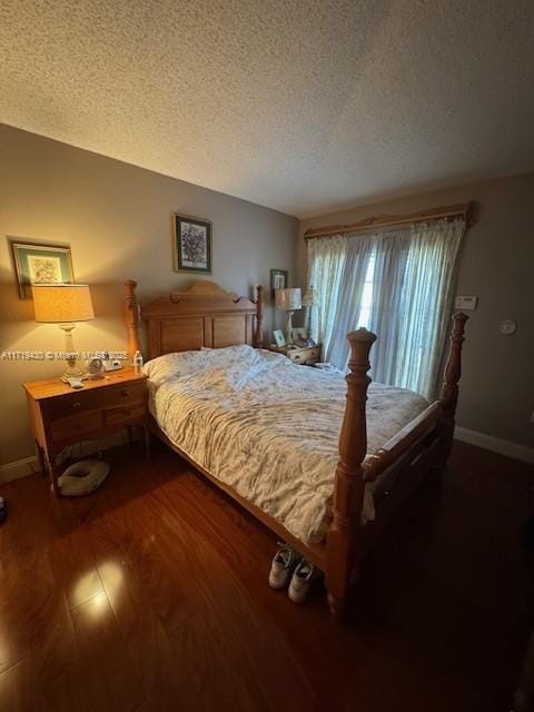 bedroom featuring a textured ceiling and dark wood-type flooring