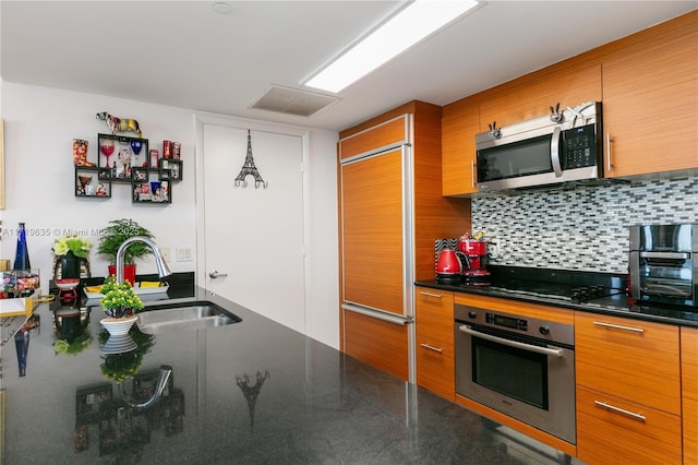 kitchen with tasteful backsplash, stainless steel appliances, sink, and pendant lighting