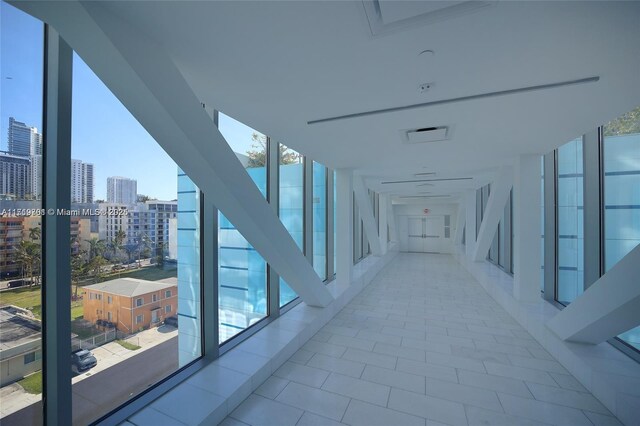 hall featuring floor to ceiling windows and light tile patterned floors