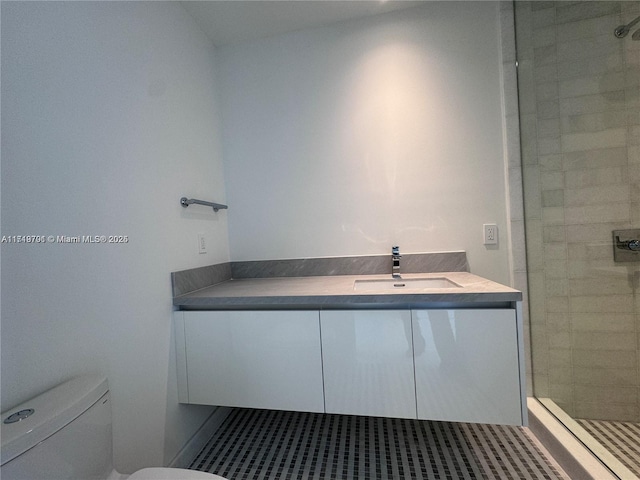 bathroom featuring a tile shower, vanity, and toilet