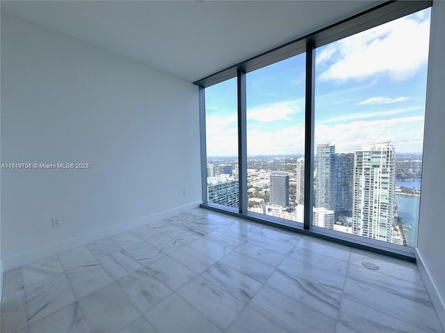 spare room featuring a water view and a wall of windows