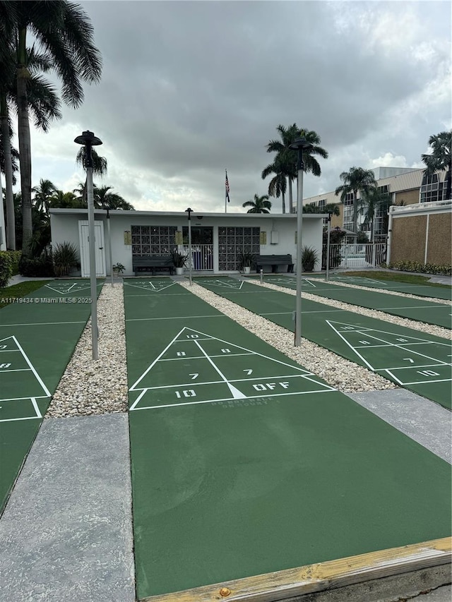 view of community featuring shuffleboard and fence