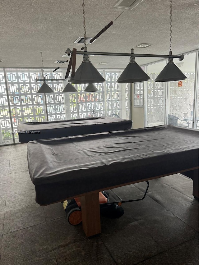 recreation room featuring a healthy amount of sunlight, a textured ceiling, and billiards