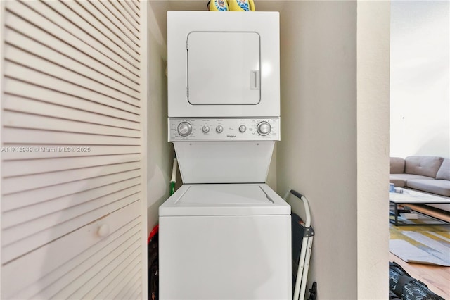 clothes washing area with stacked washing maching and dryer