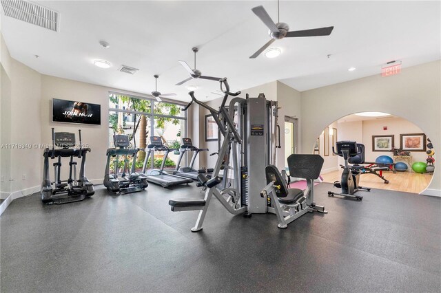 exercise room featuring visible vents, ceiling fan, and baseboards