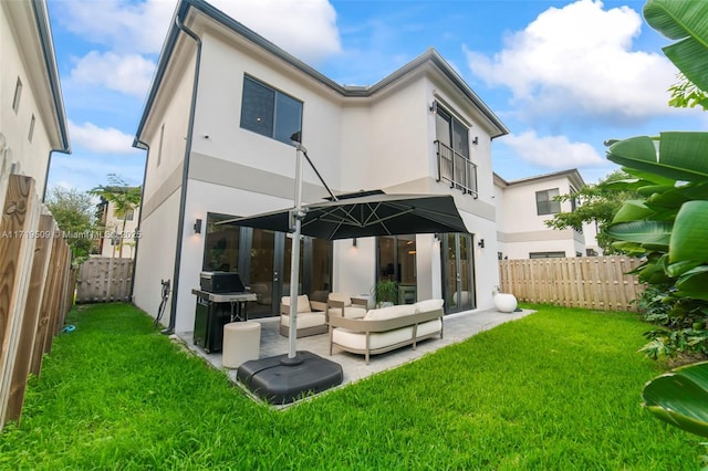 back of house featuring outdoor lounge area, a patio area, and a yard