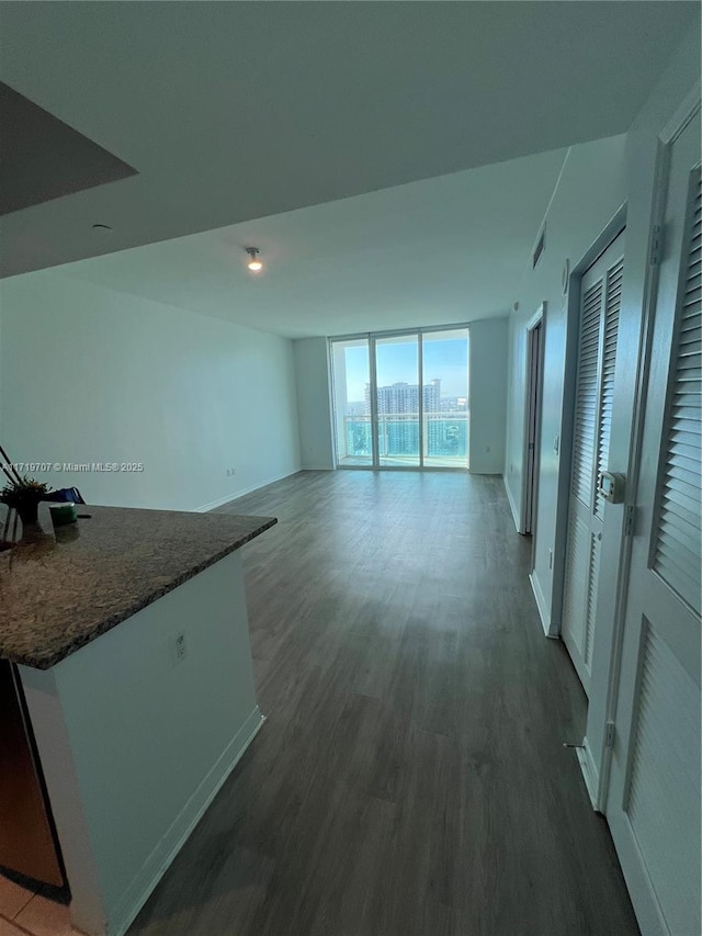 unfurnished living room with expansive windows and dark hardwood / wood-style flooring