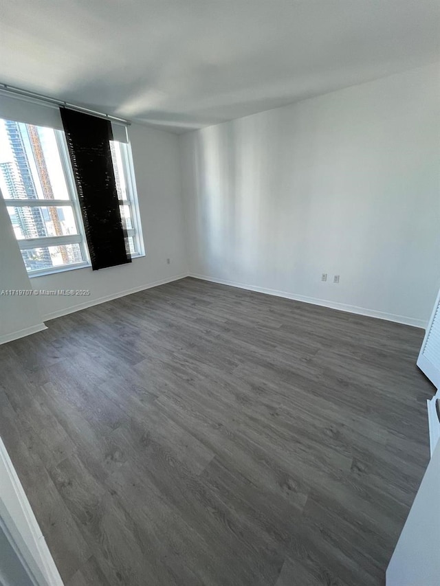 unfurnished room featuring dark wood-type flooring