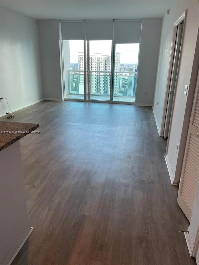 unfurnished living room with dark wood-type flooring