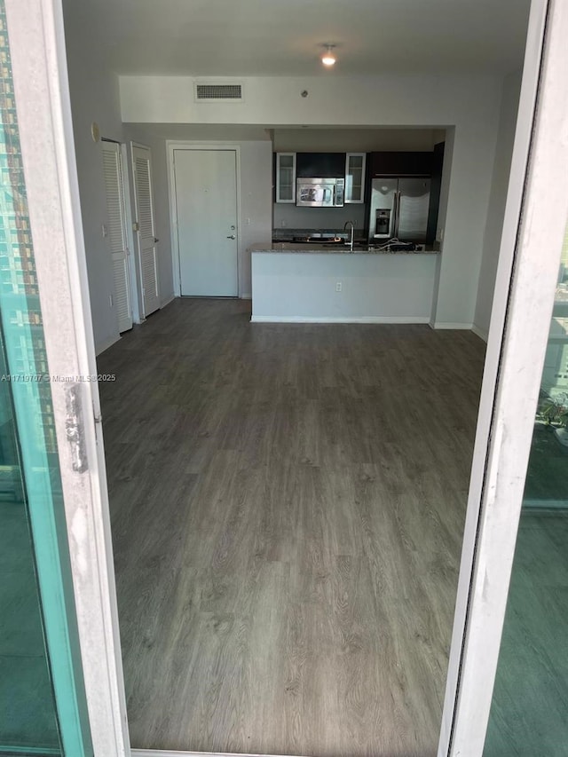 unfurnished living room with dark hardwood / wood-style floors and sink