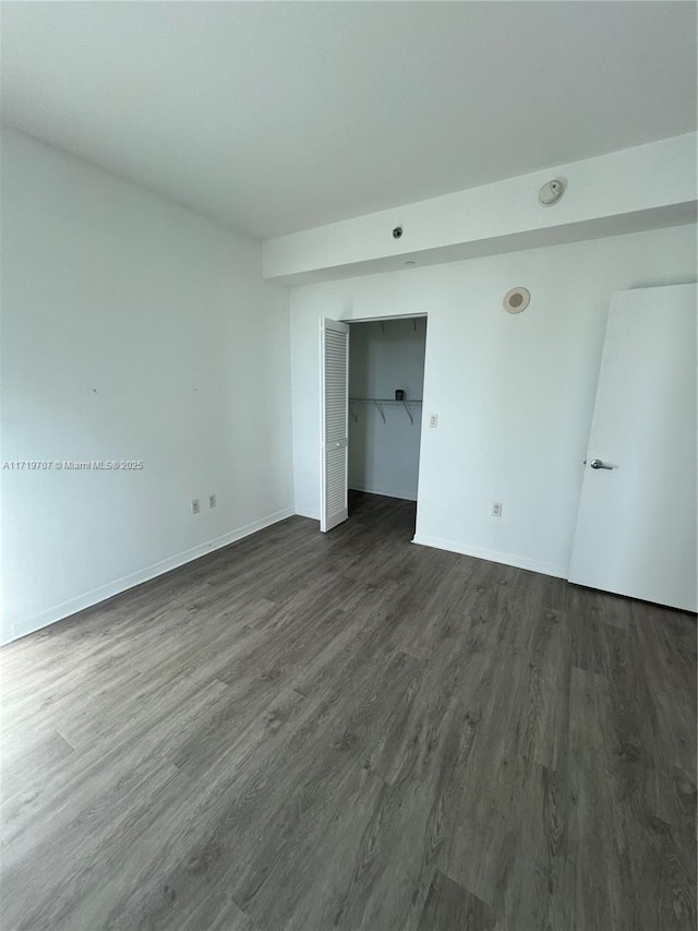 empty room with dark wood-type flooring