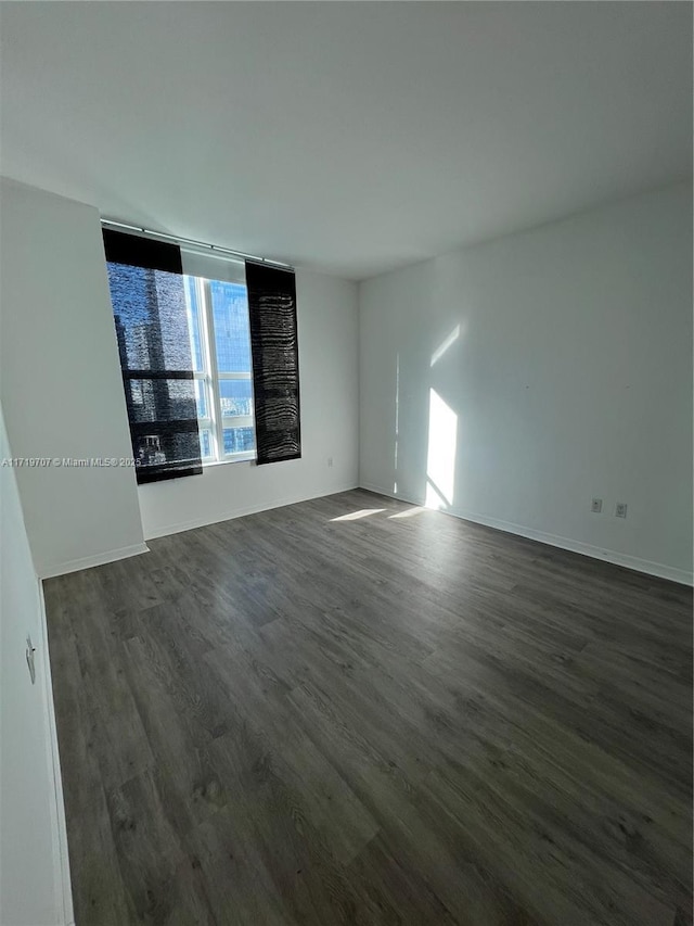 empty room with dark hardwood / wood-style floors