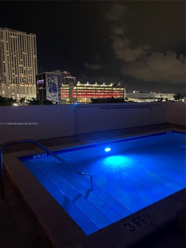 view of pool at twilight