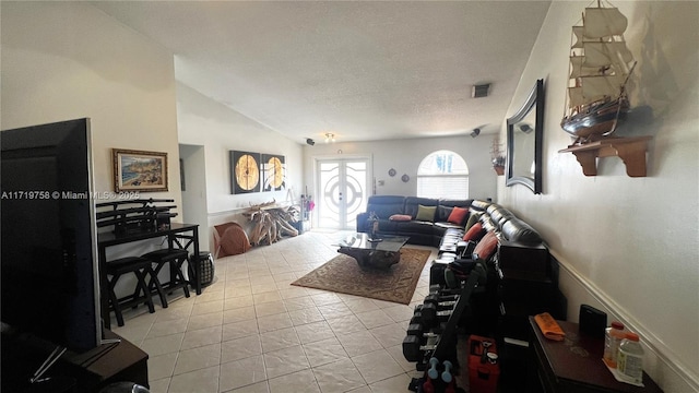 living room featuring a textured ceiling, light tile patterned floors, and vaulted ceiling