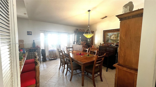 tiled dining area with vaulted ceiling