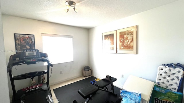 workout room with tile patterned floors and a textured ceiling