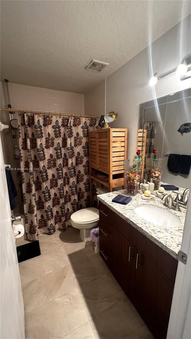 bathroom with a textured ceiling, toilet, and vanity