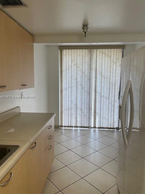 kitchen featuring light tile patterned floors and white fridge