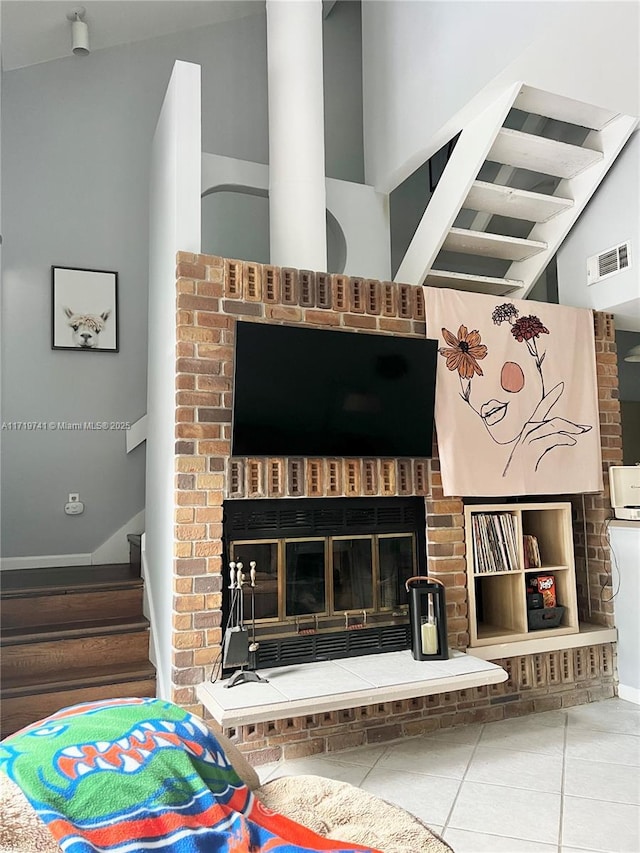 tiled living room featuring a brick fireplace