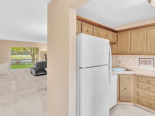 kitchen featuring white appliances, tasteful backsplash, and sink