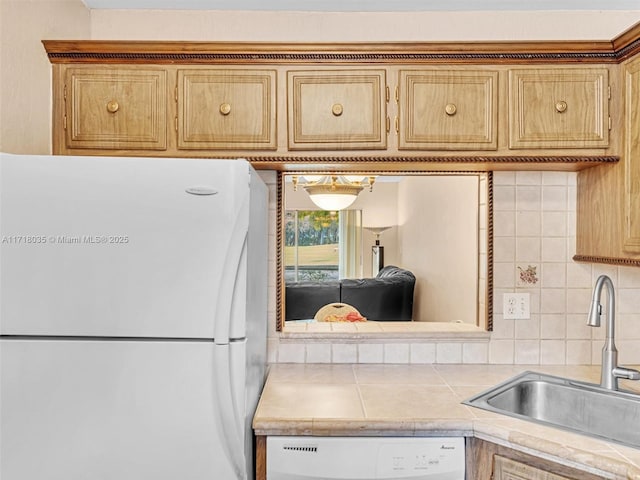 kitchen featuring white appliances, tasteful backsplash, and sink